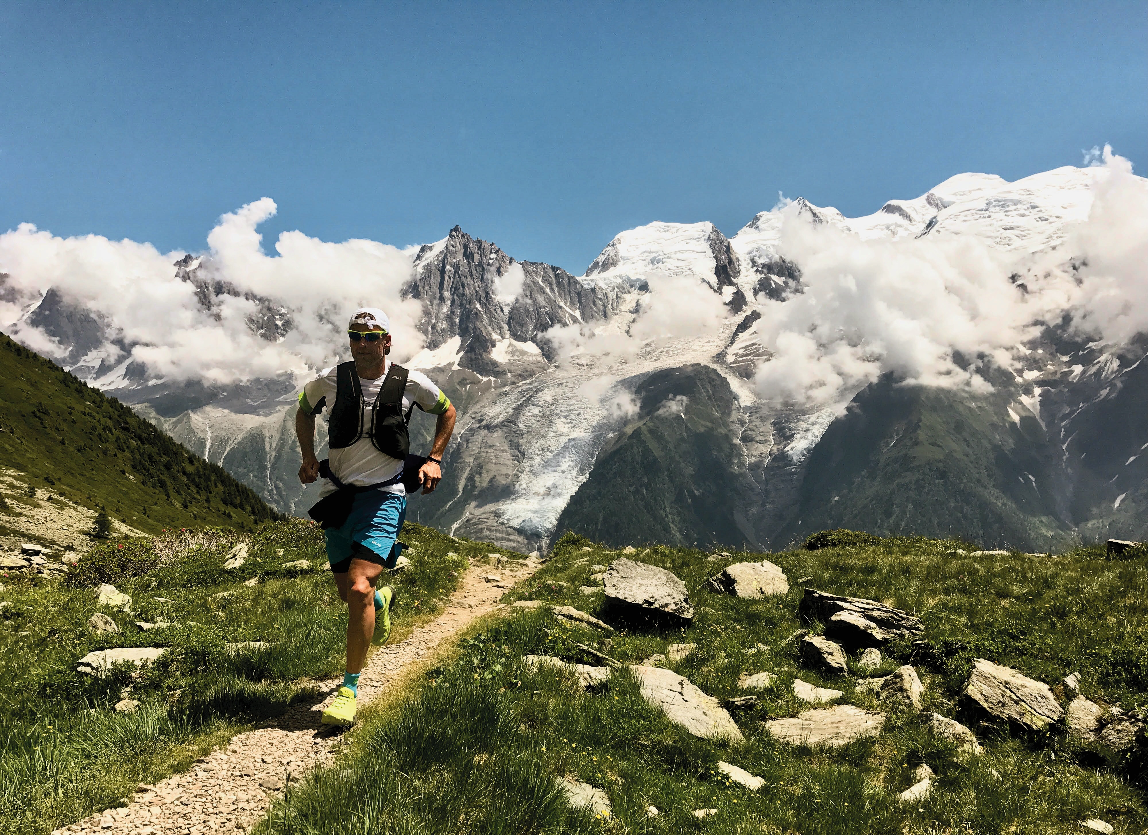 Trail runner navigating an alpine ridge path overlooking Chamonix valley